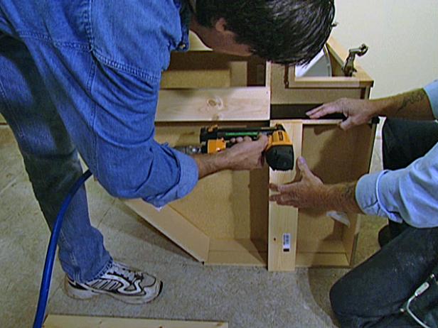 Turn each of the cabinets on its side and attach a pine 1x4 board to the bottom of the framework.