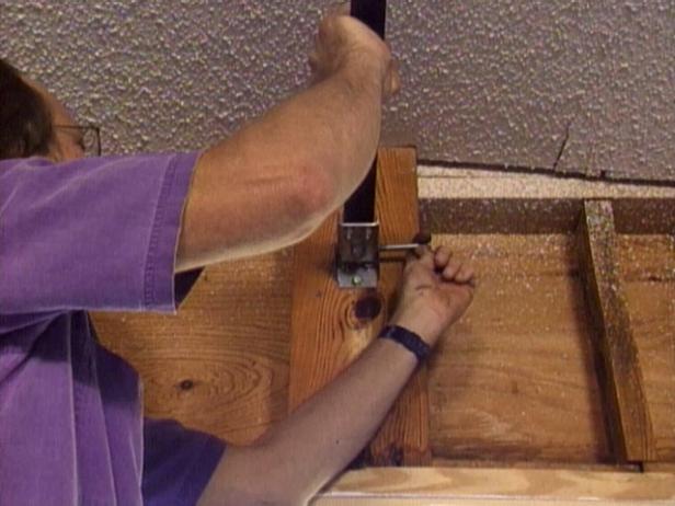 Disconnect the track by unscrewing or unbolting it from the doorframe. If you're planning to replace your automatic door opener, remove the opener's track from above (Image 2).