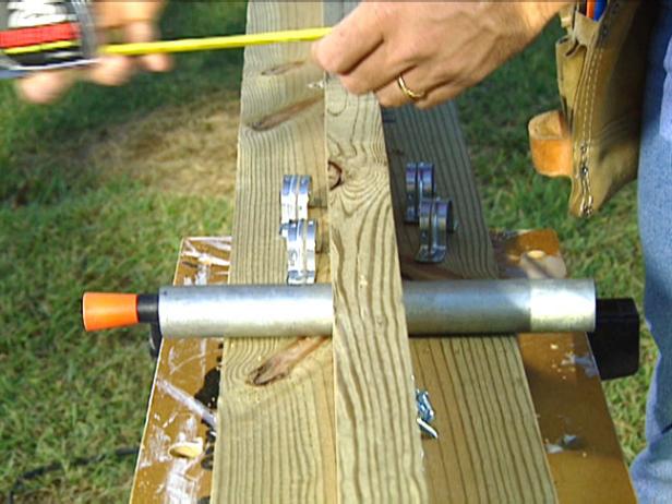 Position a piece of galvanized pipe in the notched area. The pipe should be long enough to allow a 1-1/2" overhang on each side. Add pipe straps to further secure the pivot bar.