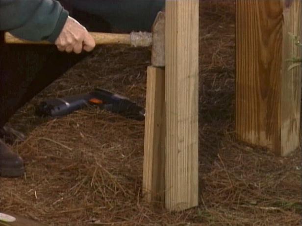 Secure the bottom of the support of your deck to a stake after checking the support for plumb.