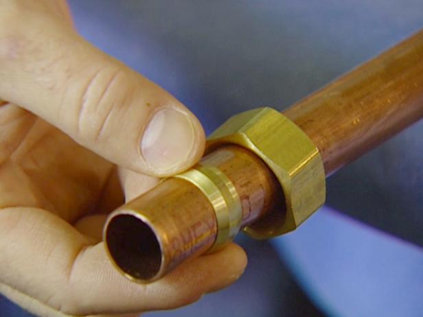 Place a compression nut, small end first, on one of the cut pipe ends. Slide on the ferrule. Repeat the same steps on the other side.
