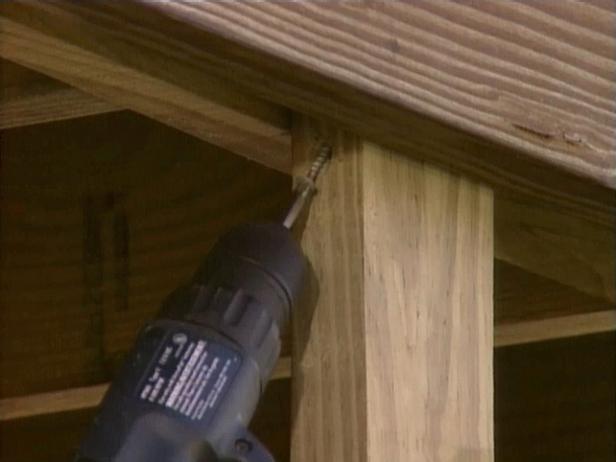 Create a 2 inch by 4 inch support for the door and toenail the top of the support to the deck.
