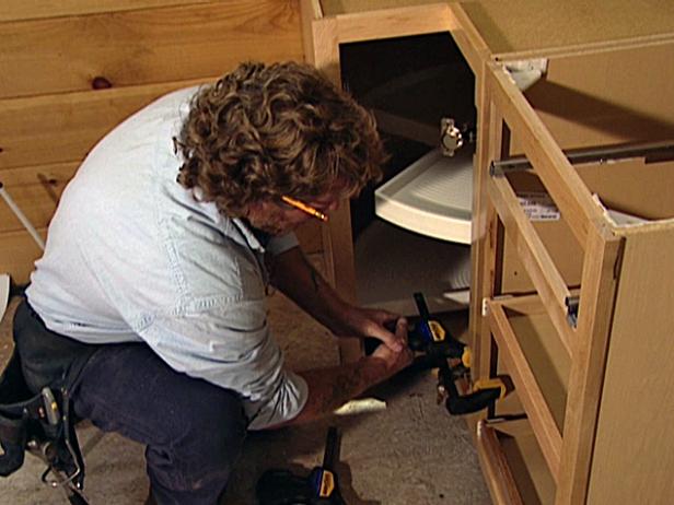 Place the first two cabinets in position and clamp them together using quick release bar clamps.