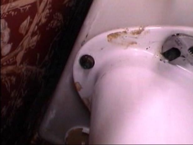 To remove the toilet base, use a large screwdriver to support the head bolt, then, turn the nut under the tank with an adjustable wrench until the entire bolt is removed from the tank.