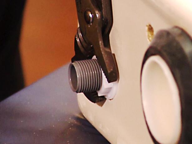 To secure the fit of the seal, guide the assembly through the hole, then put the tank seal into place. The tank seal is located on the ballcock and hand tighten the locking nut. Use a small pair of slip joint pliers to get a more secure fit.