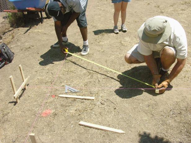 Measure and adjust the stakes until the strings form a square and level representation of the deck dimensions.