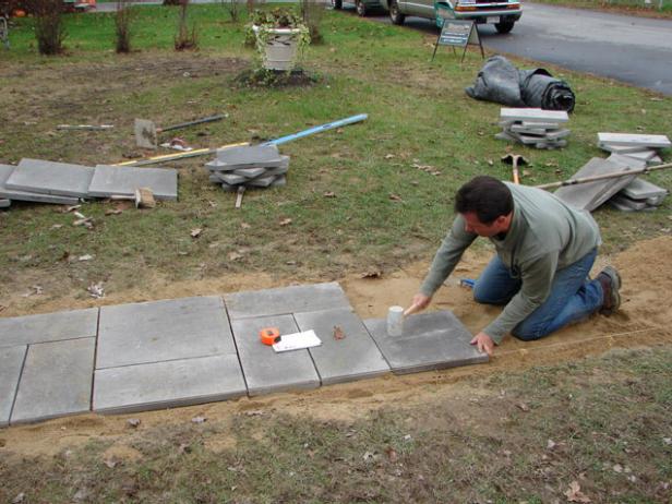 Use a rubber mallet to pack stone into sand Use a rubber mallet to pack stone into sand