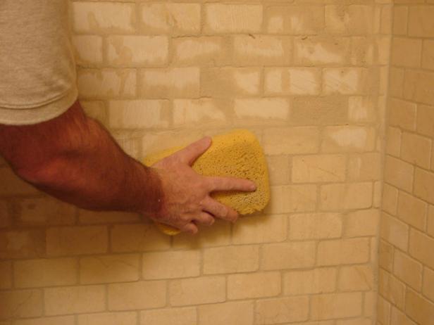 Once all the joints in a section are filled, let it dry a little bit, then wipe the grout off the surface with a sponge and clean water.