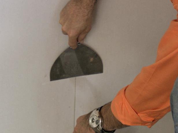 Tape the seams between the drywall panels with mesh tape. This tape is designed to prevent visible cracks from appearing along the joints of the drywall sheets.
