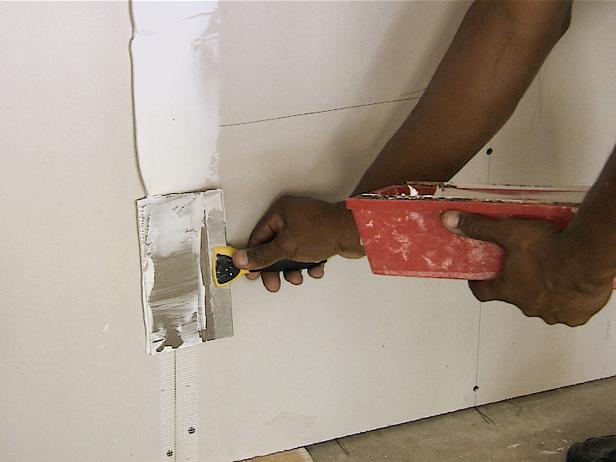 The edges of the sheets of drywall are recessed or beveled. The reason for this is to allow for the mudding process so that the walls will be completely flat. Apply a narrow strip of compound to the joints, just enough to cover the tape.