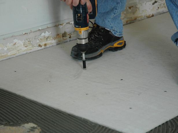 When the board is in the right place, begin screwing the backer board into the flooring below (Image 2).