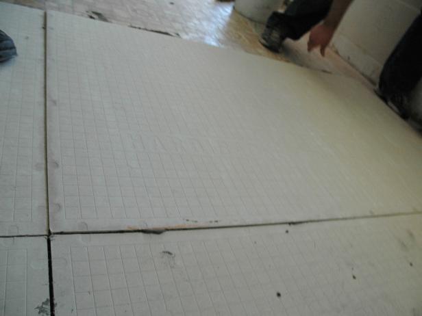The backer board has a grid to follow so the screws go in the correct location. Repeat this step until the floor is covered entirely with backer board and is completely bolted down (Image 3).