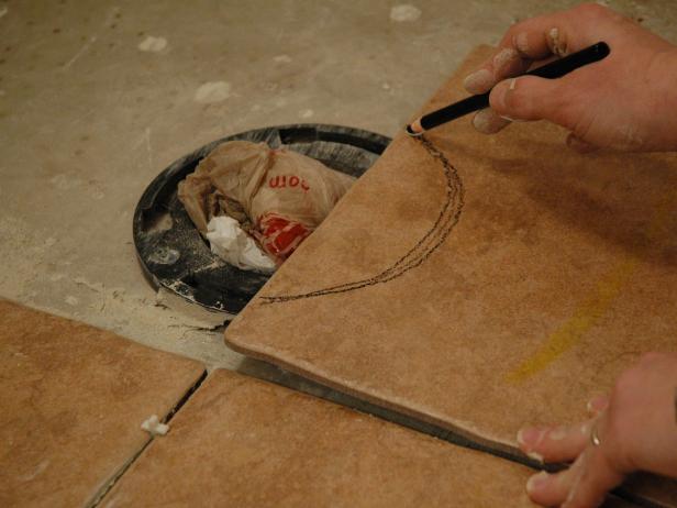 To make room for the toilet flange, draw a circle the size of the opening.