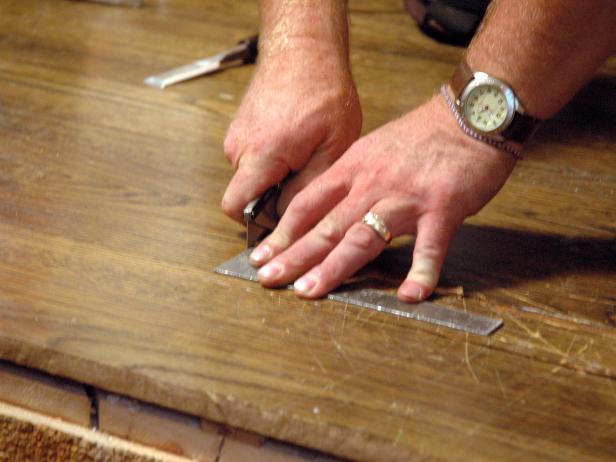 Contractor makes a straight cut on the hardwood floor to repair damage in the Disaster House.