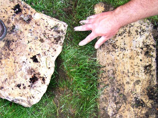 Use pieces of the grass sod previously set aside to fill any gaps between the flagstones and the surrounding turf.