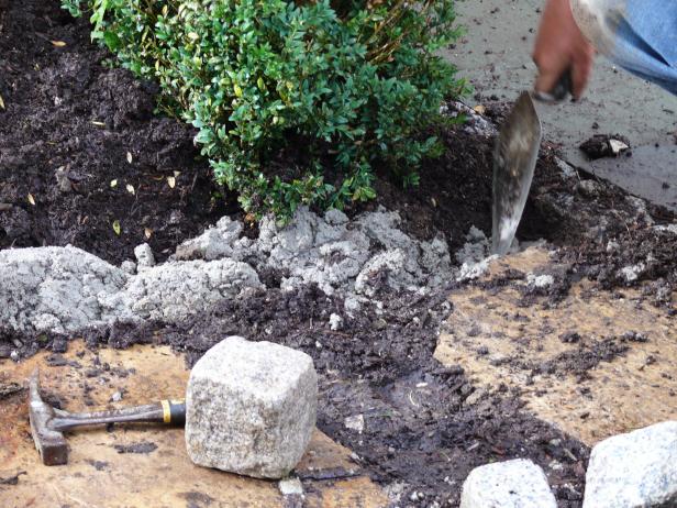 Dig a shallow trench, approximately six inches wide and six inches deep, on each side of the walkway. Next, mix preblended cement-sand mortar mix according to the manufacturer's instructions. For convenience, prepare just enough at a time to remain workable for a half hour or so.
