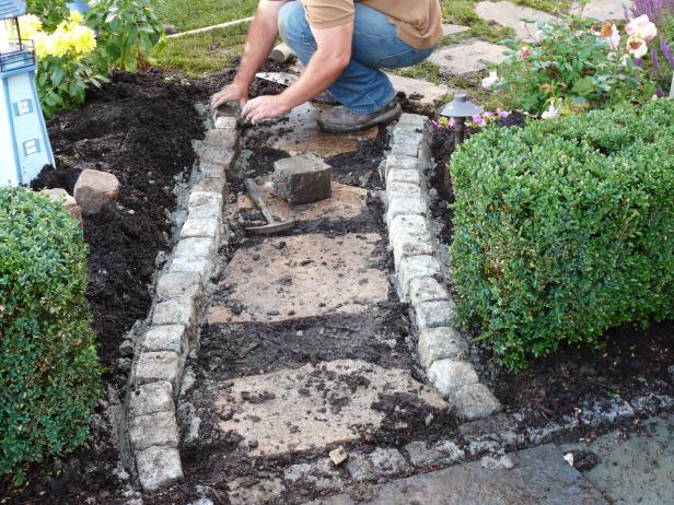 Place a three-inch deep layer of mortar in the trench bottom and seat 4-inch cobblestones in the mortar trench.