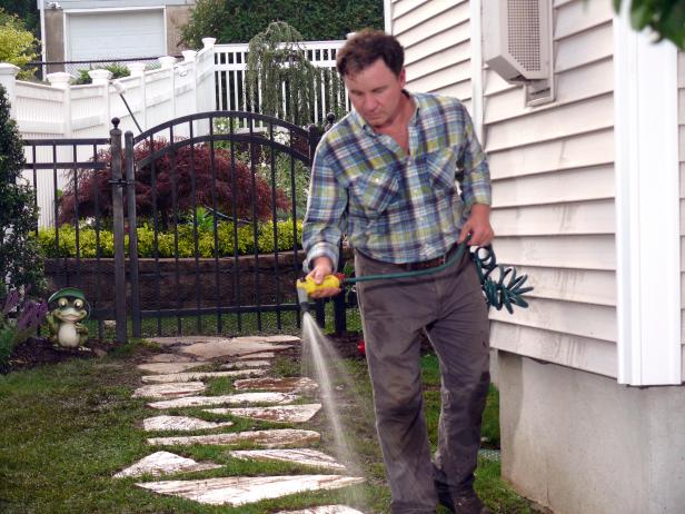 Clean off debris from the stone walkway path with a garden hose which will also begin to rejuvenate the turf that was transplanted for this project.