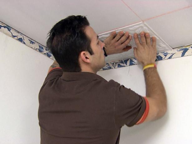 Marc installs tin ceiling tiles in the room of this home improvement project.