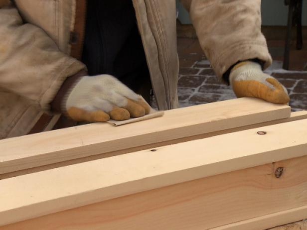 Man sands the wood for this home improvement project before staining it.