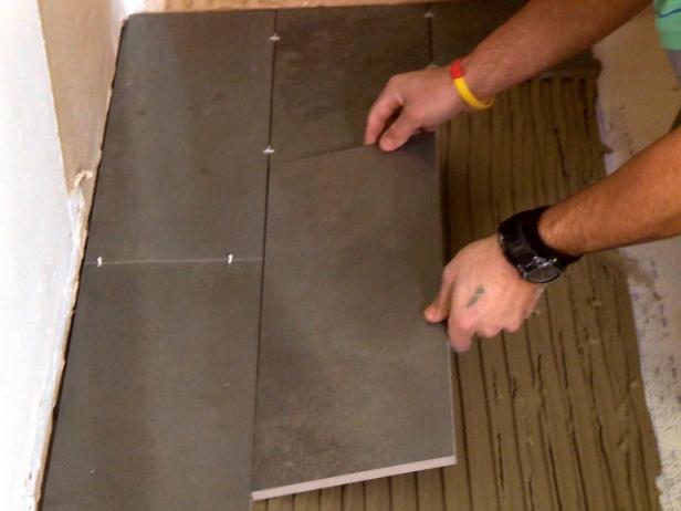 Laying plank floor tiles over mortar mix on ground in this home improvement project.