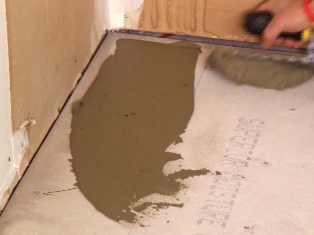 Spreading mortar on floor area to do plank tile floor installation.