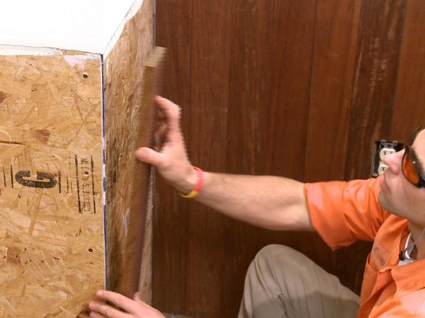 Adding boards to wall in this wainscoting home improvement project.