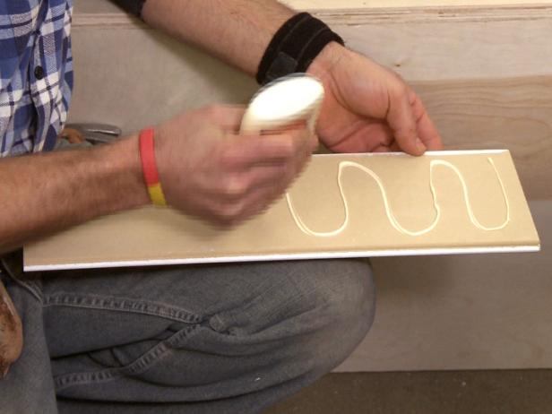 Adding wood glue to beandboard in this banquette construction project.