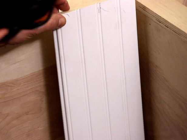 Close up of a beadboard being installed in the banquette furniture installation.