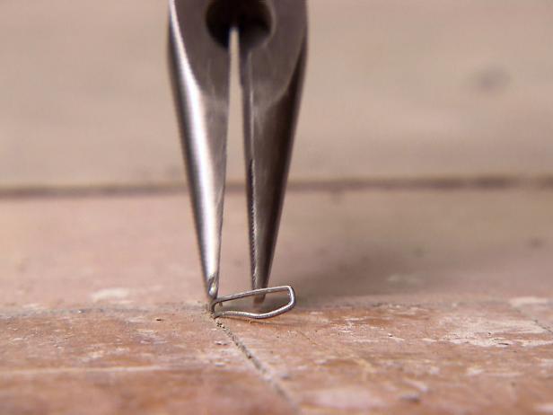 Close up of a toll removing old nails from floor.