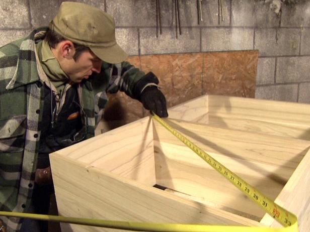 Host measures the wooden wine rack frame before adding the diagonals.
