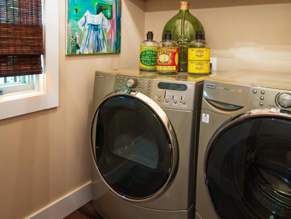Neutral Laundry Room With Stainless Steel Appliances, Colorful Artwork and Matchstick Blind Covered Window Neutral Laundry Room With Stainless Steel Appliances, Colorful Artwork and Matchstick Blind Covered Window