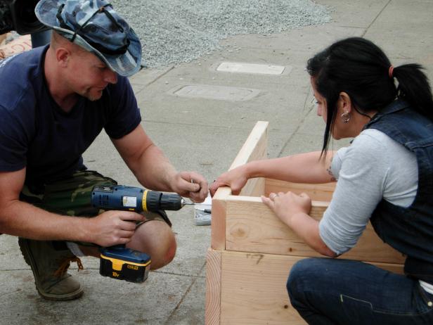 With a sweet design and hard work, this back yard comes to life with a concrete chic fire feature - contractors attach the wood pieces to make the surrounding base of the fire pit.