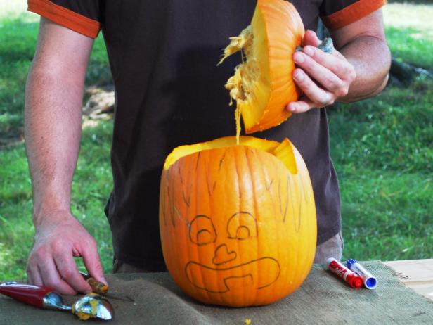 Use a carving tool or knife to cut above each spike from tip to tip. Make your way around the entire pumpkin then remove and discard the lid. Use an ice cream scooper to scrape out all the pumpkin guts.