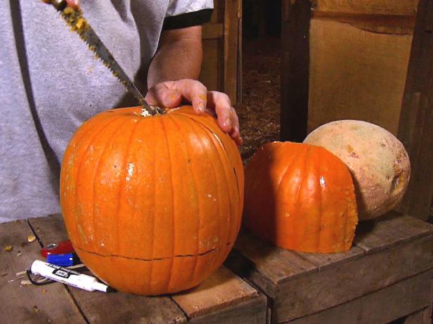 Decide which side of the pumpkin you would like to use for the face. There will be a lot of cutting and fitting, so you should focus on making that side look and fit the best. With a design plan in mind, use a small hand saw or knife to cut a section from the large pumpkin.