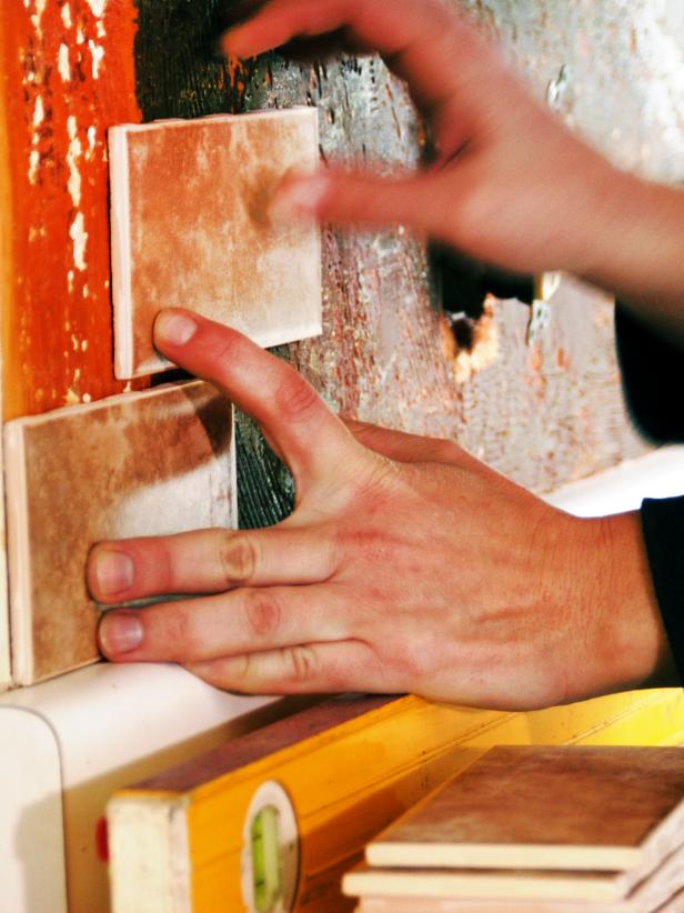 Before you apply mastic and begin tiling, do a dry run by lining up the edge of one tile with the center mark, then place tiles side by side to determine how many tiles will be needed and the width of the end pieces