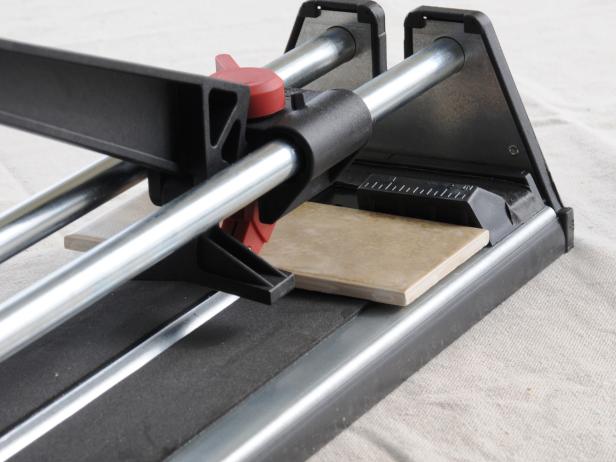 While you are dry-fitting the tiles and before you apply the mastic, make your bottom row and end cuts. You can use a manual snap cutter for most ceramic or porcelain tile