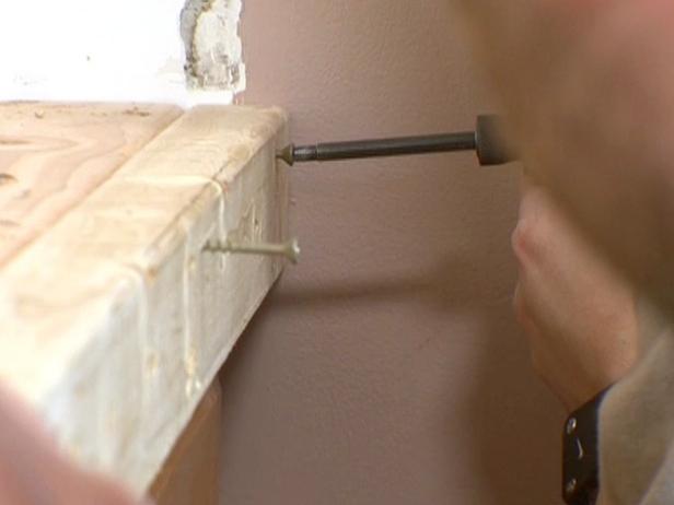 Close up of drill adding screws to front of wood edge.
