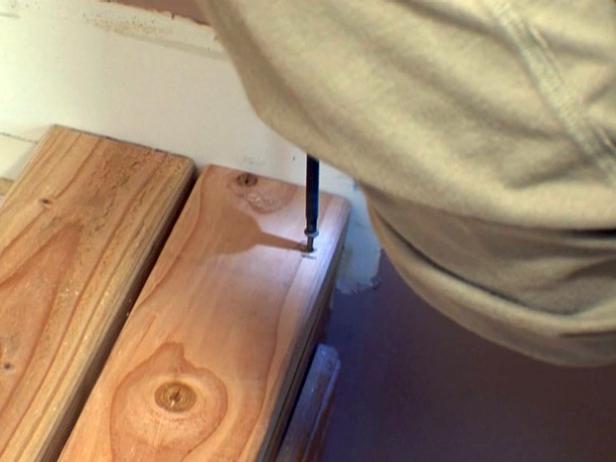 Using a drill to attach wood pieces.
