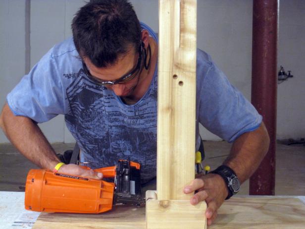 Marc uses a nail gun to attach base to kitchen cart in this furniture construction project.