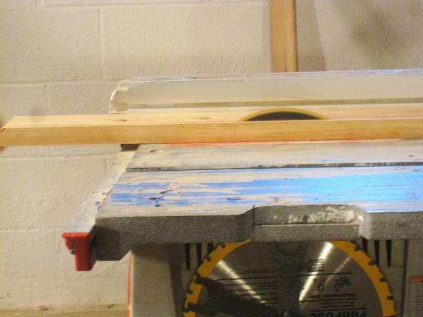 A saw cuts into the wood to construct a kitchen cart.