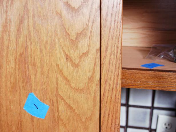 Blue painters tape used to number the cabinet doors.