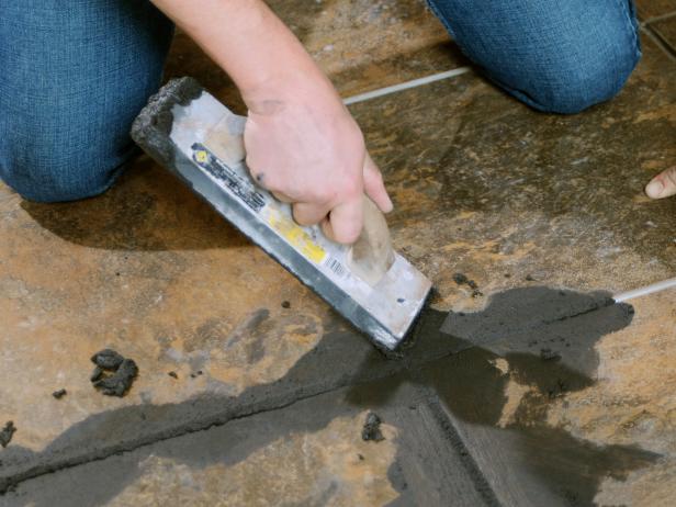 Closeup of Josh spreading grout inside the tile seams.