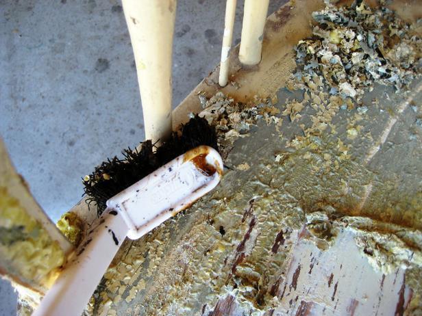 While the stripper is still wet, use the brush to remove paint in areas the putty knife cannot reach and to give it an overall scrub. We used three different sizes of brushes: a brass brush the size of a large toothbrush, a medium brush and a larger brush.