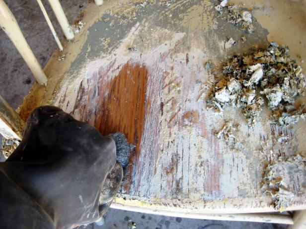 Once you have the majority of the paint off, wipe the chair down with steel wool to remove any remaining stripper and paint, and to prevent the stripper from drying on the wood surface.