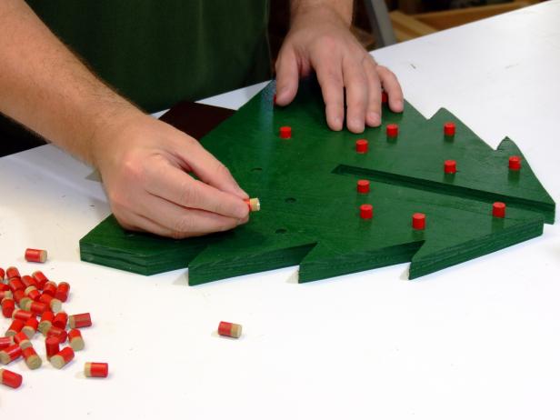 Apply a dab of glue on the bottom of the berries and insert into the holes in the tree sides as shown here. Use a wooden or rubber mallet to tap the berries in place if needed.