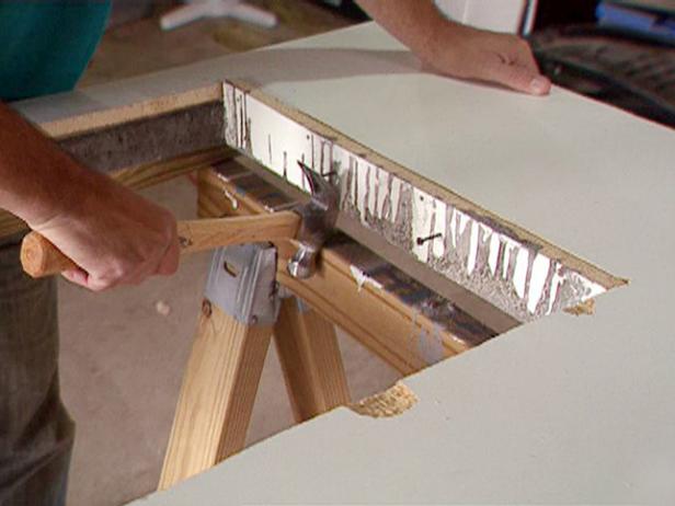 Remove the screws holding the mold sides to the base, then use a hammer and the new screws to pry each side away from the concrete slab.