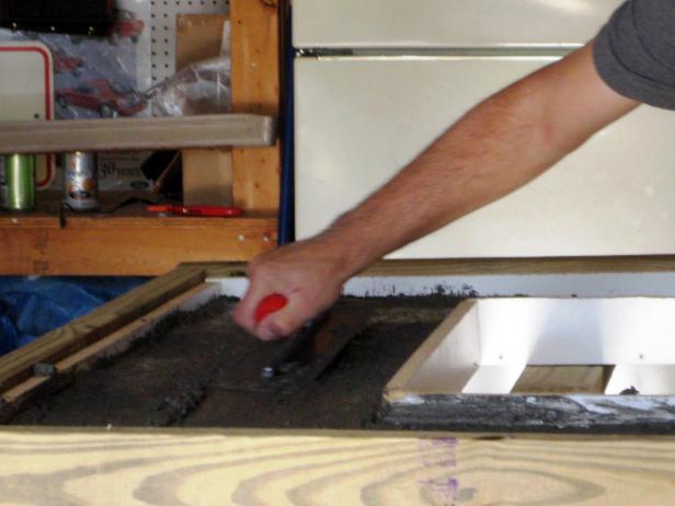 When the concrete is ready, pour it into the mold to the desired thickness and smoothing it with a trowel.