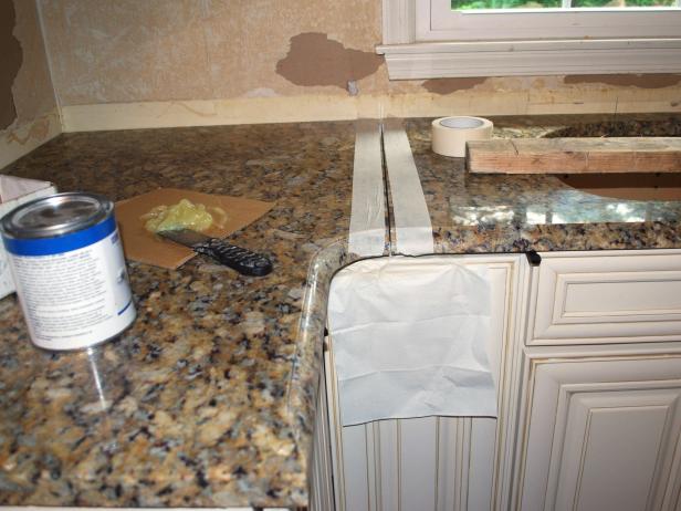 With the slabs flush and level on the cabinets, if you have multiple slabs, now is the time to fit them together. First, tape the edges to protect them. Join the butt seams using color-matched two-part epoxy, which you can purchase from the fabricator shop.
