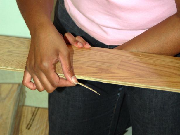 With a sharp chisel or utility knife, cut off the tongue of the plank you're installing against.
